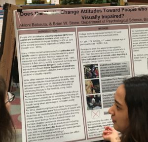 Student next to conference poster entitled Does the media change attitudes toward people who are blind or visually impaired?